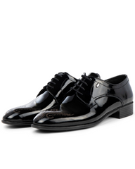 Pair of black patent leather dress shoes on a white background