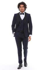 Navy tuxedo with satin details and a shawl lapel, including a white shirt and bow tie.